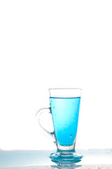 Water splashing into glass of water on white