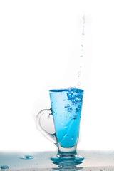 Water splashing into glass of water on white