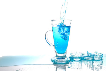 Water splashing into glass of water on white