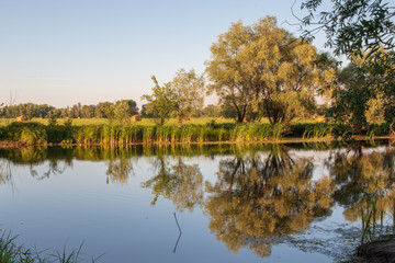 Fototapeta na wymiar A peaceful river landscape at summer sunset.Late afternoon.