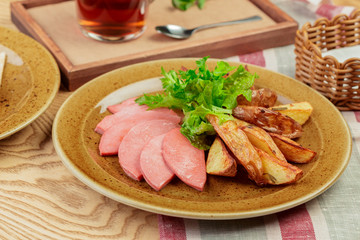 Roasted potatoes with ham slices close up