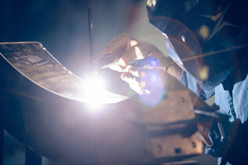 Welder working on bronze component