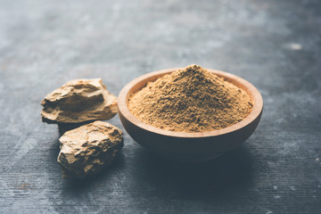 Fuller'S Earth Clay OR Multani mitti in a bowl along with raw stones and mortar