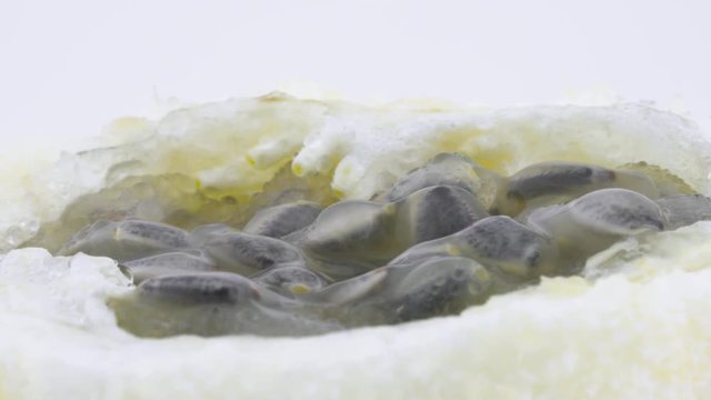 Macro shooting of sweet granadilla pulp. Slowly rotating on the turntable isolated on the white background. Close-up.