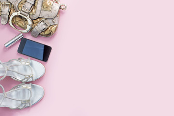 Modern fashion accessories young women shoes handbag phone gadget lipstick cosmetics pink background.