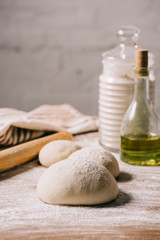 Fototapeta premium selective focus of raw dough for pizza and ingredients on tabletop