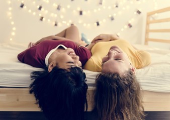 Women lying on the bed and laughing