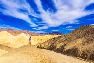 Fototapeta na wymiar Man in the background of the Death Valley, California, USA. Copy space for text. Back view..