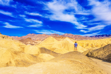 Man in the background of the Death Valley, California, USA. Copy space for text. Back view..