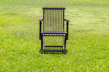 Black wooden chairs on the lawn.