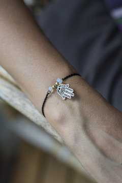Female hand wrist resting with tiny jewelry
