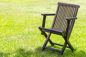 Black wooden chairs on the lawn.