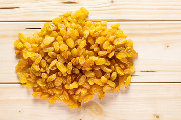 Lot of whole dry golden raisins sultana variety stack flatlay on natural wood