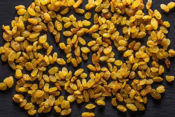 Lot of whole dry golden raisins sultana variety flatlay on grey stone