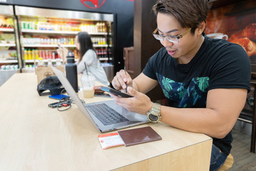 Traveler man using internet on smart phone and laptop, waiting for airplane flight