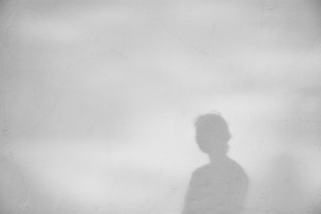Shadow of a girl on a white concrete wall