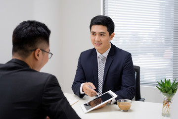 Business meeting. Two business people sitting in front of each other in the office while discussing something