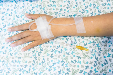 Focus on the hands of female patients take saline intravenous in the hospital.- Health care concept