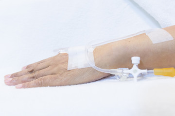 Focus on the hands of female patients take saline intravenous in the hospital.- Health care concept