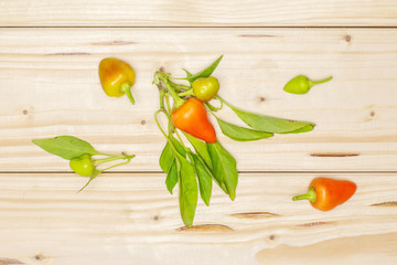 Group of six whole hot red orange chili pepper flatlay on natural wood