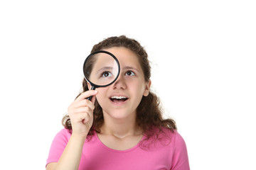 Beautiful young girl with magnifying glass on white background