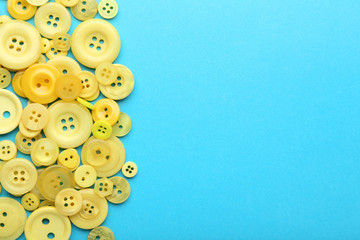Fototapeta premium Yellow sewing buttons on blue background