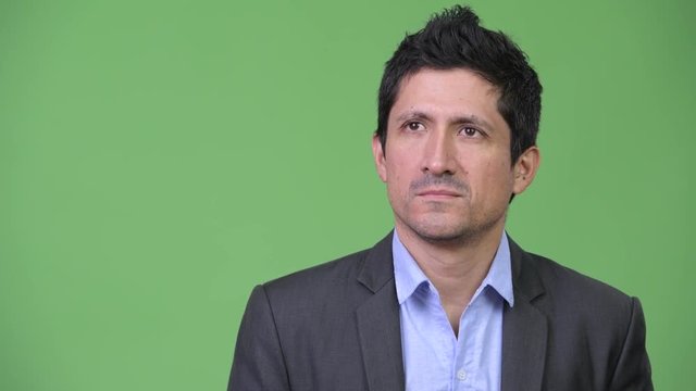 Hispanic businessman looking bored while thinking