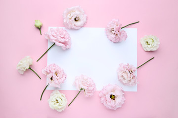 Eustoma flowers with sheet of paper on pink background