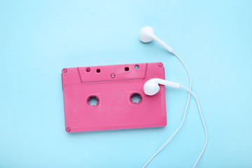 Cassette tape with earphones on blue background