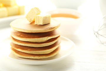 Fototapeta na wymiar Tasty pancakes with butter on white wooden table
