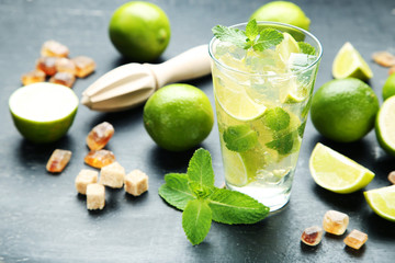 Mojito cocktail in glass with sugar on wooden table