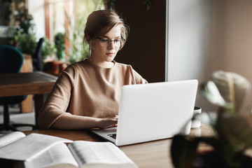 Work, lifestyle and business concept. Good-looking focused european female in trendy glasses...