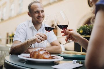 Cheerful couple in a restaurant with glasses of red wine.  Young