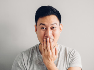 Headshot photo of Asian man with laugh face. on grey background.