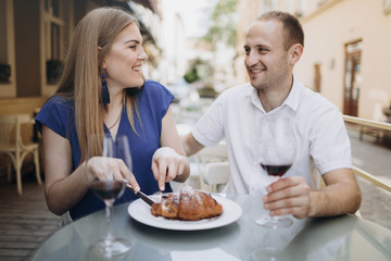 Fototapeta na wymiar Cheerful couple in a restaurant with glasses of red wine. Young