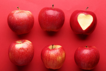 Fresh and ripe apples on red background