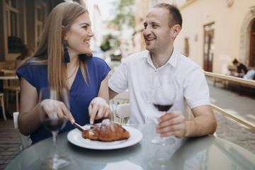 Young couple with glasses of red wine in a restaurant . 