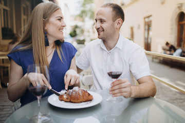 Cheerful couple in a restaurant with glasses of red wine.  Young