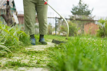 Woman mowing the grass, the mower close up