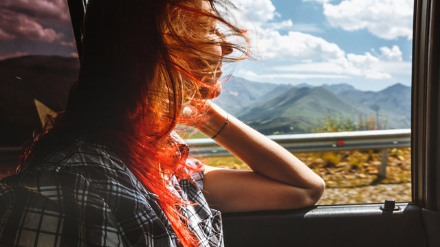 Freedom car travel concept - young woman relaxing out of window in a car. Road trip