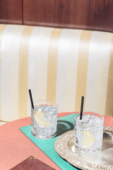 Tumbler with gin and tonic, into an elegant pop-colored bar