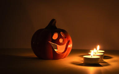Halloween candle pumpkin on a yellow background.