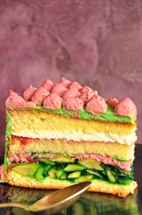 A piece of sponge cake with cream and apples on a pink background