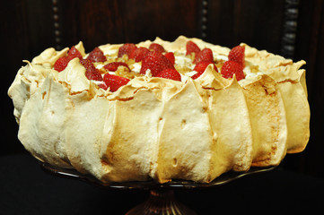 Pavlova meringue cake with strawberries on a dark background. Strawberries on a meringue cake