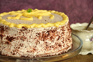 Chocolate-lemon cake on a glass pate on a purple background