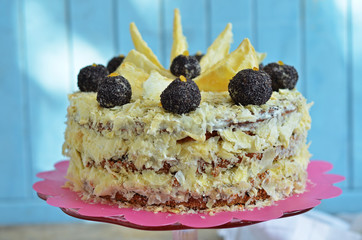 Poppy seed cake with cream on a blue background. Poppy balls on the cake