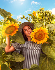 Close-up portrait of beautiful joyful woman with sunflower.