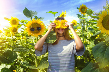 Happy girl with sunflowers on eyes.