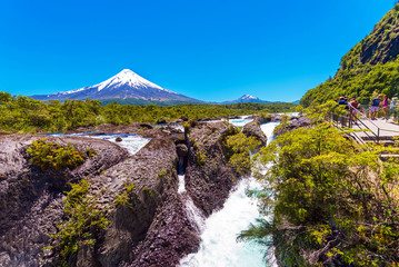 Fototapeta premium Salutos de Petrohue waterfalls and volcano Osorno, Puerto Varas, Chile. Copy space for text.