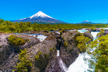 Fototapeta premium Salutos de Petrohue waterfalls and volcano Osorno, Puerto Varas, Chile. Copy space for text.